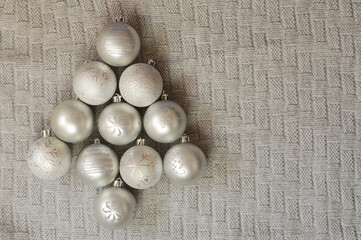 gray balls in the form of a Christmas tree. toys for Christmas and New Year decorations on a gray knitted plaid. winter holidays.