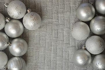 gray shiny Christmas balls on a knitted plaid. background for Christmas and New Year. winter holidays.