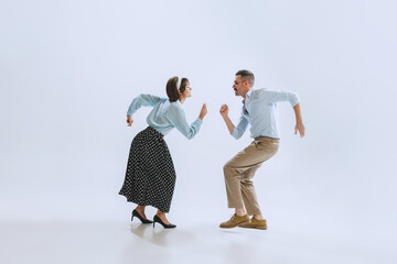 Two dancers, young man and woman in old-school fashioned attire dancing rock-and-roll isolated on...