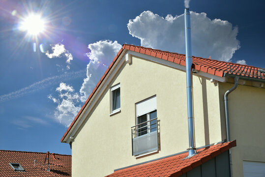 Schornstein, Außenkamin aus Edelstahl an der Fassade eines Wohngebäudes