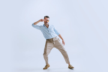 Portrai of young man, hipster or dandy dancing rock-and-roll or swing isolated on white background....