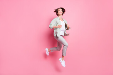 Full size photo of cute young lady run wear grey green suit isolated on pink color background