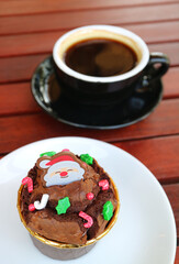 Plate of Delectable Christmas Chocolate Cupcake with Blurry Hot Coffee in the Backdrop