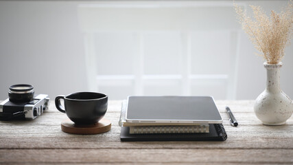 Naklejka na ściany i meble Black coffee cup and tablet with camera and tablet on wooden table