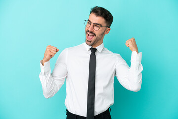 Business caucasian man isolated on blue background celebrating a victory