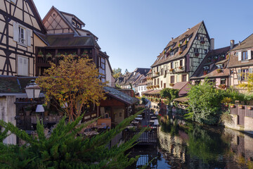 Fototapeta na wymiar Traditional Alsatian half-timbered houses along the Lauch River in Little Venice tourist district of Colmar, France