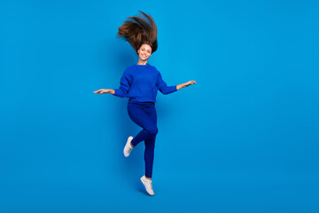 Full length body size view of attractive cheerful girl jumping enjoying good mood isolated over bright blue color background