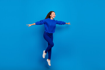 Fototapeta premium Full length body size view of attractive cheerful dreamy girl jumping flying vacation isolated on bright blue color background