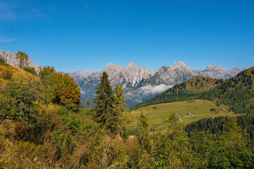 The late summer - early autumn landscape near Sauris di Sopra, Udine Province, Friuli-Venezia Giulia, north east Italy. A summer cow shed building can be seen in the clearing on the right
