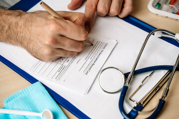  Vaccination record card. Vaccination form during the coronavirus epidemic on the doctor's table in...