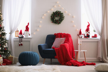 Cute Christmas gnomes in room with other festive decorations