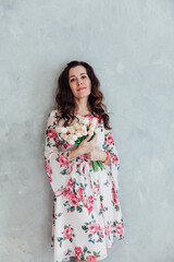 Fototapeta premium portrait of a beautiful woman in a dress with flowers on a white background