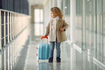 Little girl with a suitcase at the airport