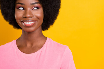 Cropped photo of young cheerful black girl happy positive smile curious look empty space isolated over yellow color background