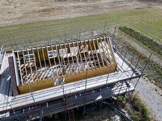 Aerial view of an unfinished barn conversion with scaffolding surrounding the structure