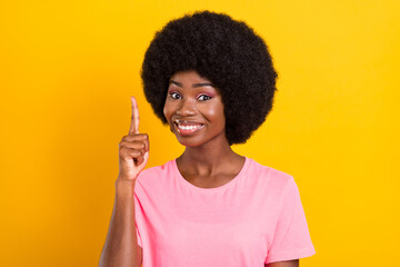 Photo of young afro girl happy positive smile point finger have idea genius isolated over yellow...