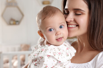 Happy young mother with her baby daughter at home, closeup
