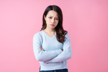 Portrait of a beautiful young Asian girl, isolated on pink background