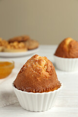 Delicious sweet muffin on white wooden table