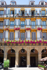 Fachada amarilla de estilo neoclásico, antiguos palcos taurinos, en la Plaza de la Constitución de San Sebastián. Tomada en San Sebastián en julio de 2021