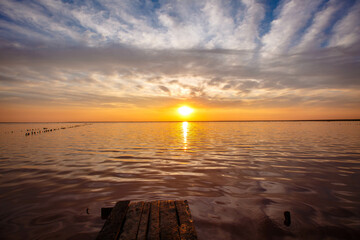Sunset on the Pink Lake in Ukraine as seen from the pier. The water looks pink because of the special algae that grows with a high salt content.