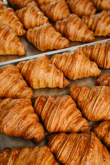 Freshly baked golden French croissants on baking sheet. Fresh classic pastries. Close up . High quality photo