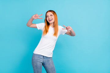 Fototapeta premium Photo of young girl happy positive smile show peace cool v-sign look empty space isolated over blue color background