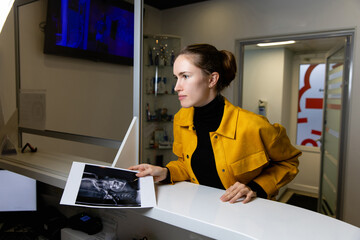 beautiful girl with a dental scan print at the reception of the dental clinic