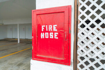 Red fire hose cabinet near the parking space ar Oceanside, California