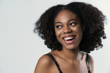 Young black woman in bra laughing and looking aside