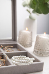 Elegant jewelry box with beautiful bijouterie on table, closeup