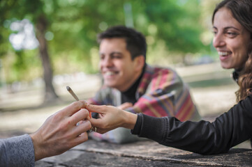 Closeup view of marijuana joint circling around hand to hand