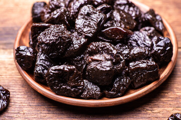Dried prunes on a wooden background. Dry fruits.