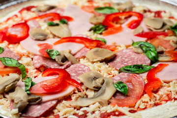 Pizza close up. Bacon, salami, mushrooms and greens.