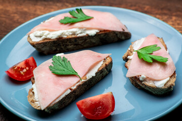 Toast with cheese and bacon on a blue plate.