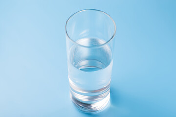 Glass of pure cold water on a blue background.