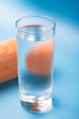 Glass of pure cold water on a blue background.