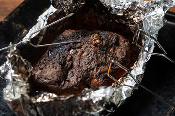 A piece of meat baked in the oven in foil. Home cooking.