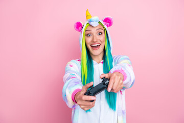 Portrait of attractive addicted cheerful girl wearing kigurumi playing game rest isolated over pink pastel color background © deagreez