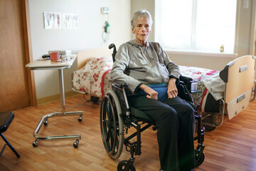 Sick, elderly senior woman in a hospital room with wheel chair