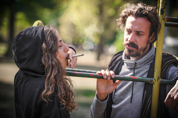 Young couple, woman and man, smoking cannabis marijuana ganja joint