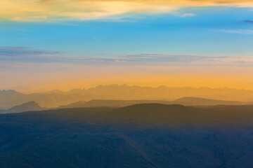 Fototapeta na wymiar Glowing sunrise shines over mountain range.