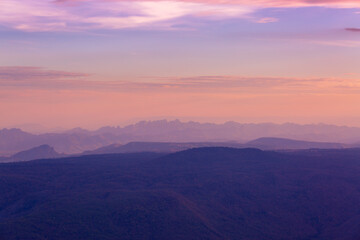 Glowing sunrise shines over mountain range.