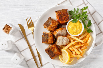fried pieces of hake on a plate with french fries