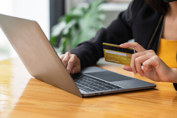 A Woman holding a laptop COMPUTER   and credit card for shopping online and payment.Blank screen monitor for graphic display montage