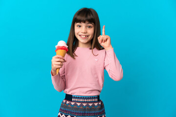 Little girl with a cornet ice cream isolated on blue background pointing up a great idea