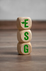 Tower made of cubes, dice or blocks with acronym ESG -  environment social governance  on wooden background