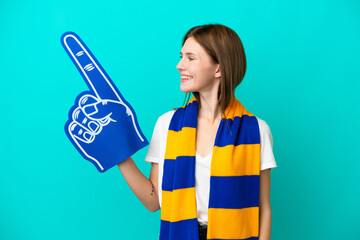 Young sports fan woman isolated on blue background looking side