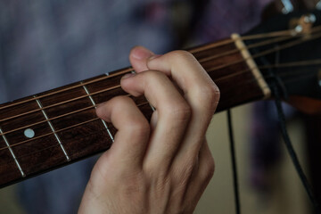 Hand playing on a guitar.