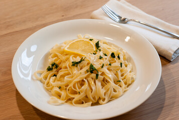 Italian Lemon Pasta or Tagliatelle al Limone on a White Plate with Parsley